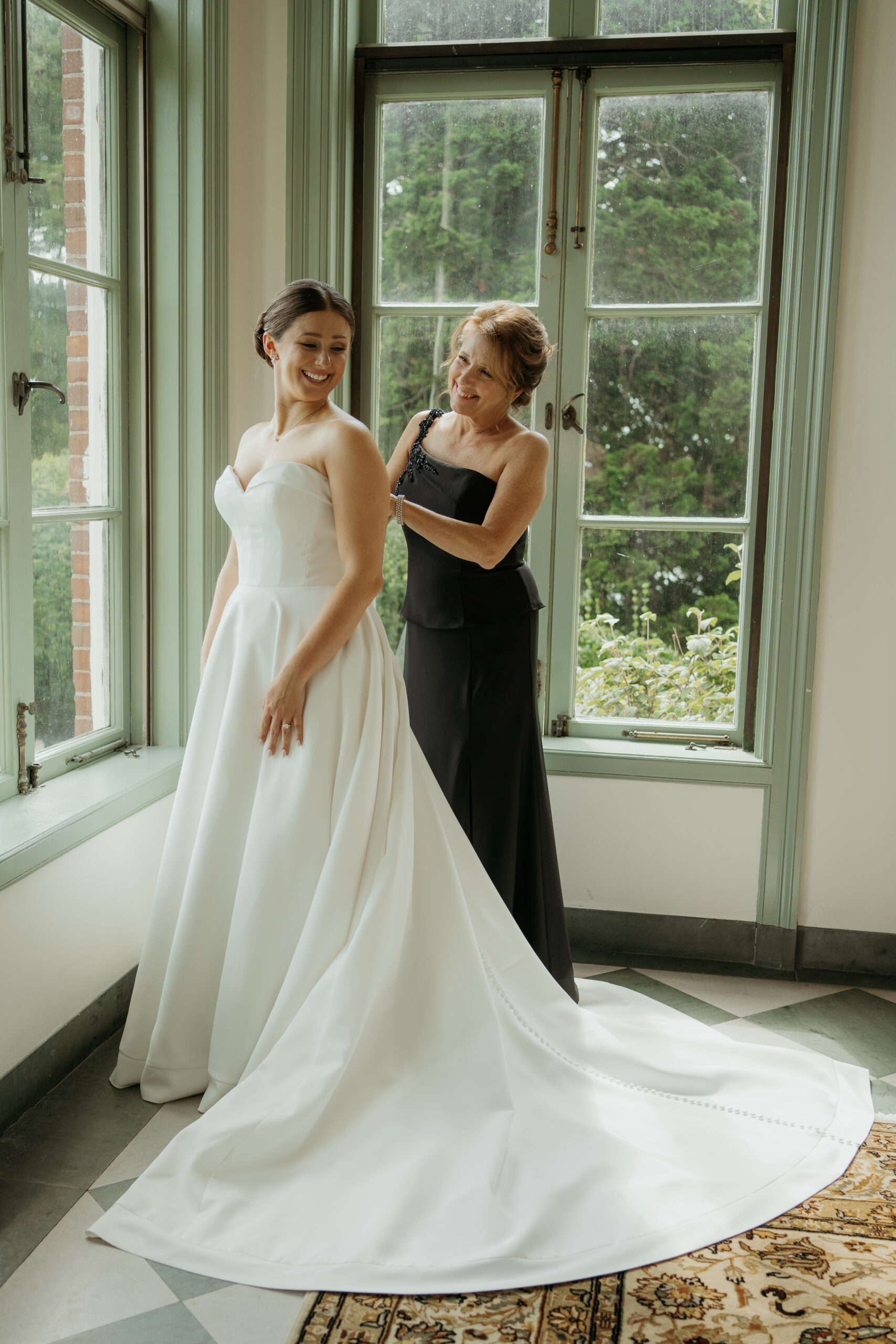 Bride and her mom getting ready as her mom helps put her elegant wedding dress on at Misselwood in Beverly, MA