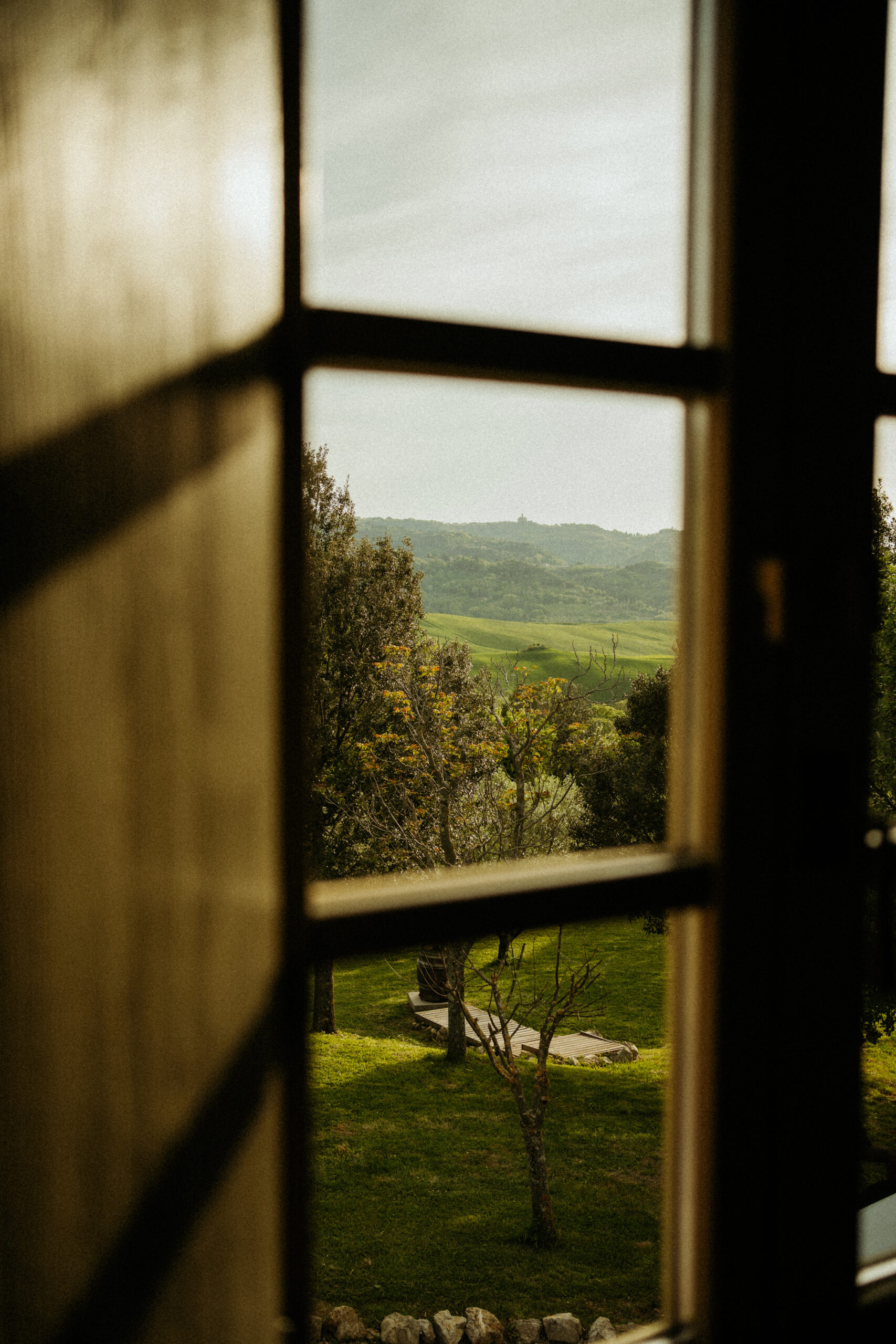 Window view of the romantic rolling hills of tuscany, the perfect backdrop for an Italian destination wedding weekend