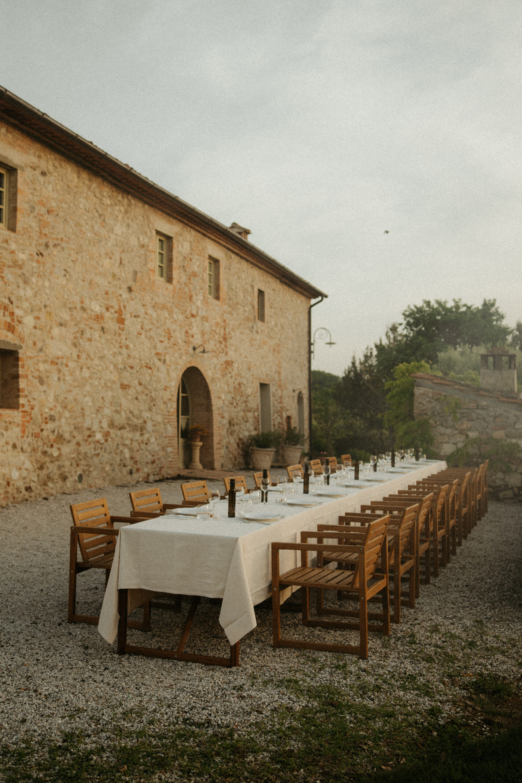 Banquet Table outside a Villa in Tuscany Italy prepped for an al fresco wedding welcome dinner