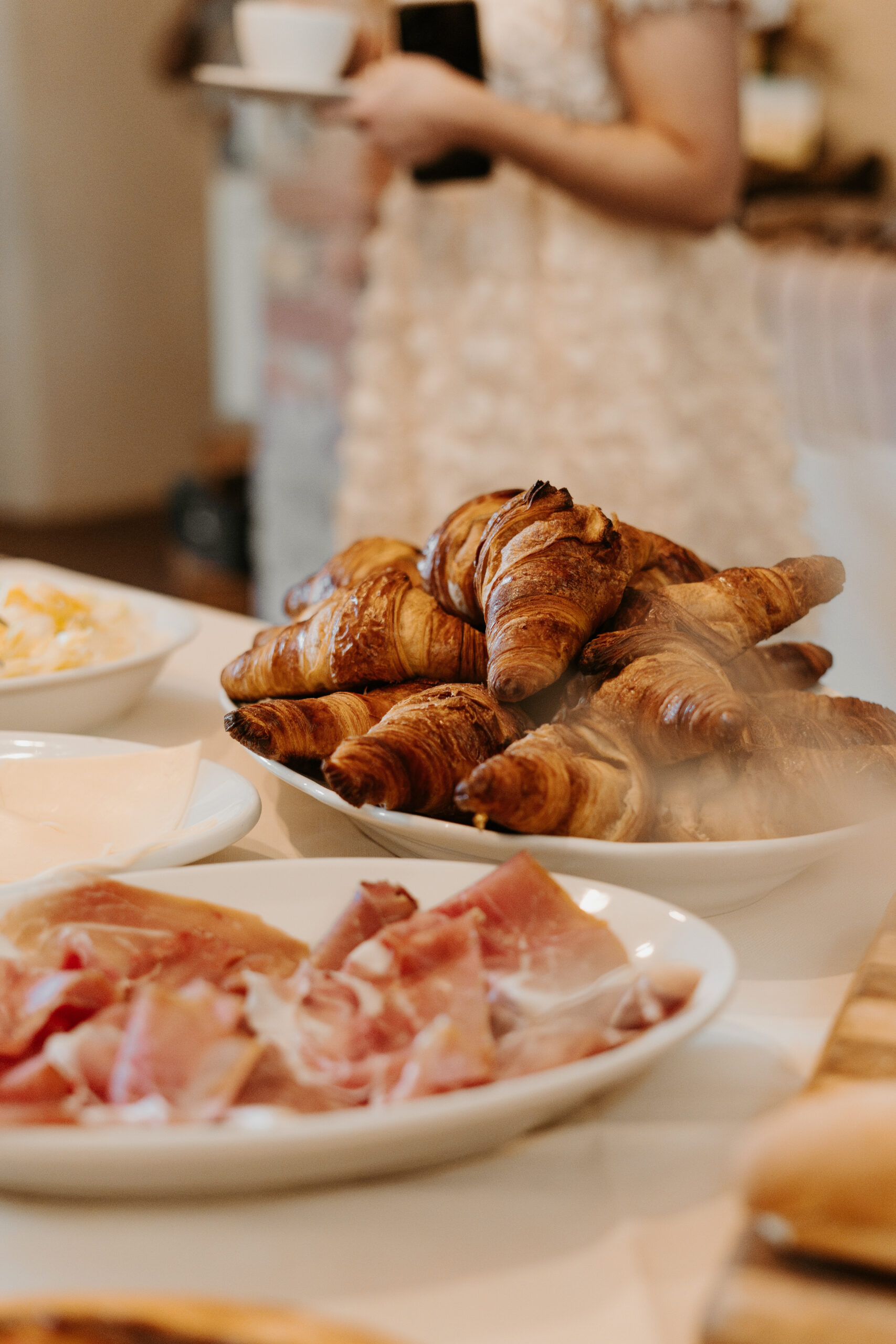Fresh crossiants and meat are splayed on the table for this Italian destination wedding bridal brunch