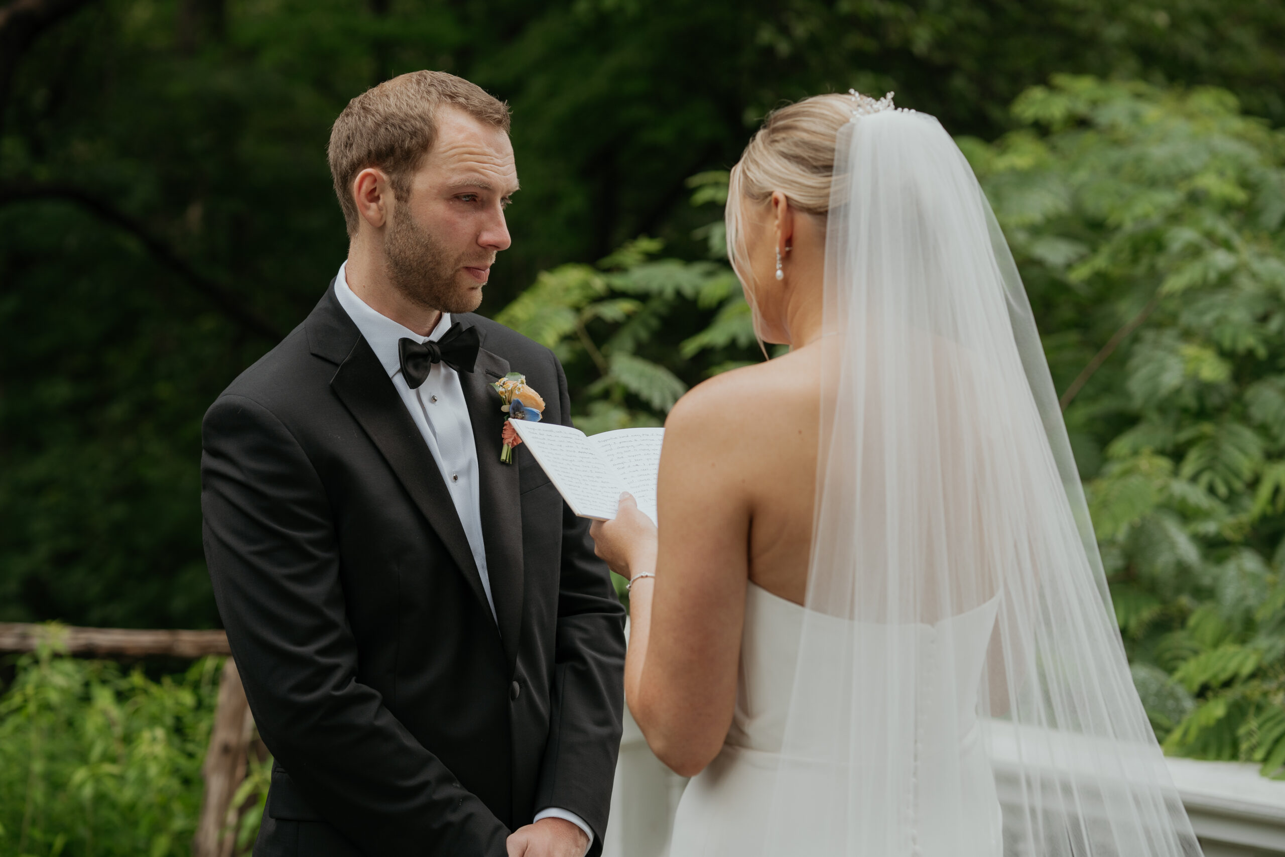 Groom sheds a tear as he listens to the beautifully touching vows his bride tells him. You see the brides vows over her shoulder but your main focus is the emotions of the groom.